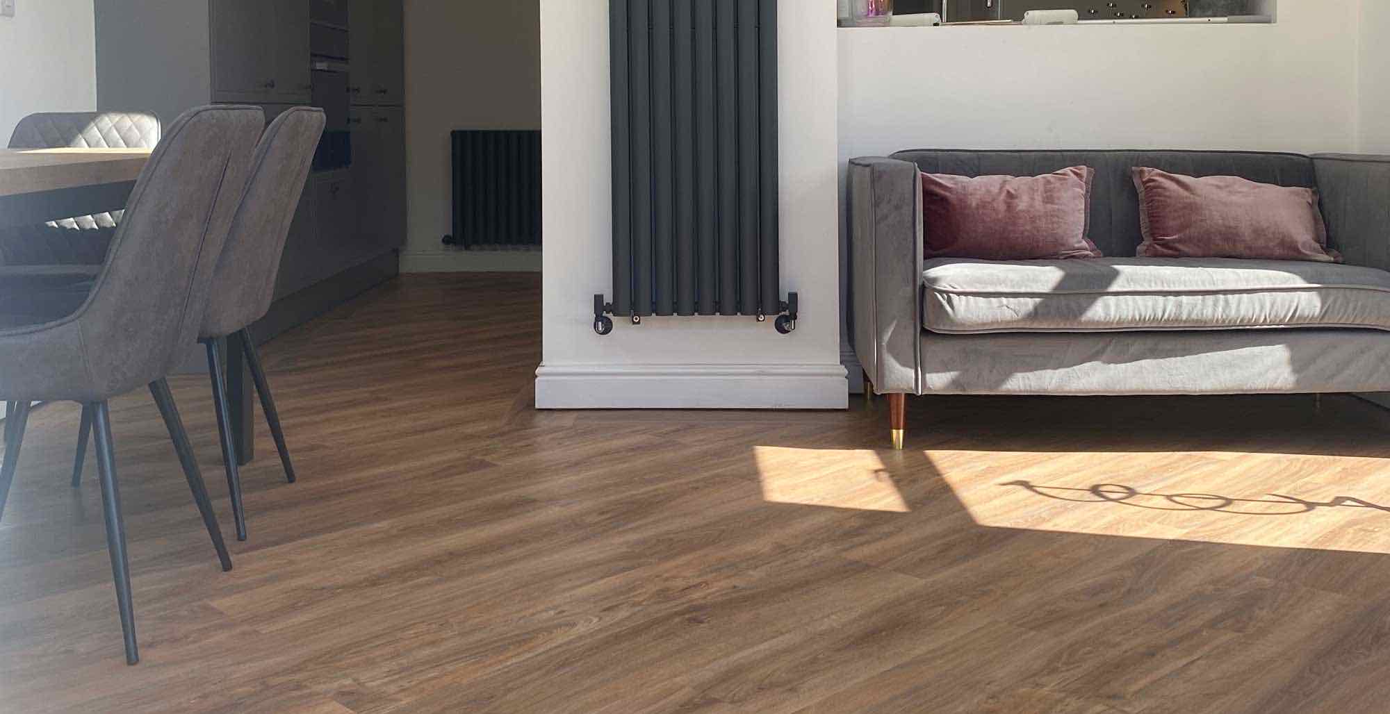 Warm oak-effect LVT running through an open-plan kitchen and living room